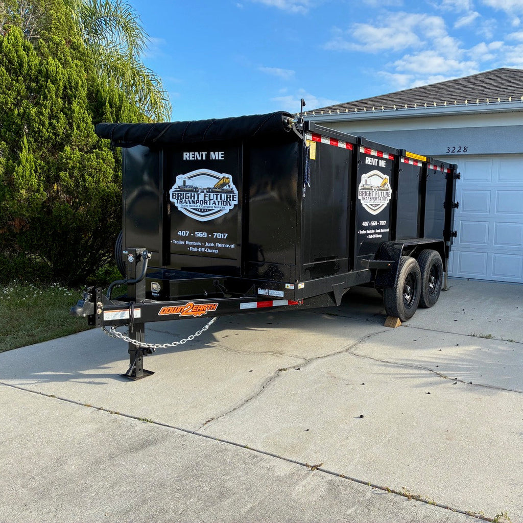 Dump truck trailer with rental company branding parked in a driveway.